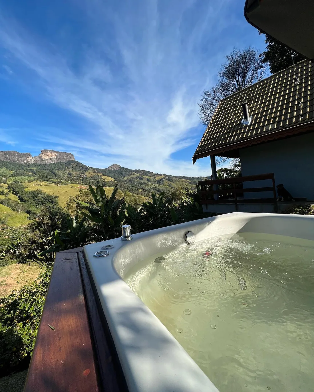 Hidromassagem em primeiro plano com a Pedra do Baú visível ao fundo, em um dia claro