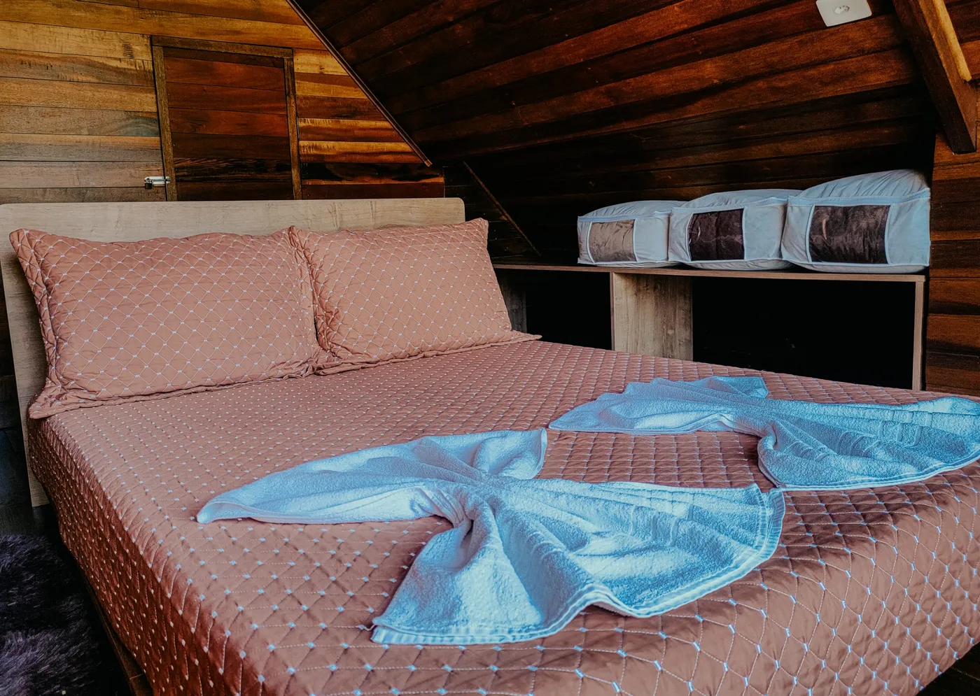 Cama Queen Size do chalé, arrumada com roupa de cama clara