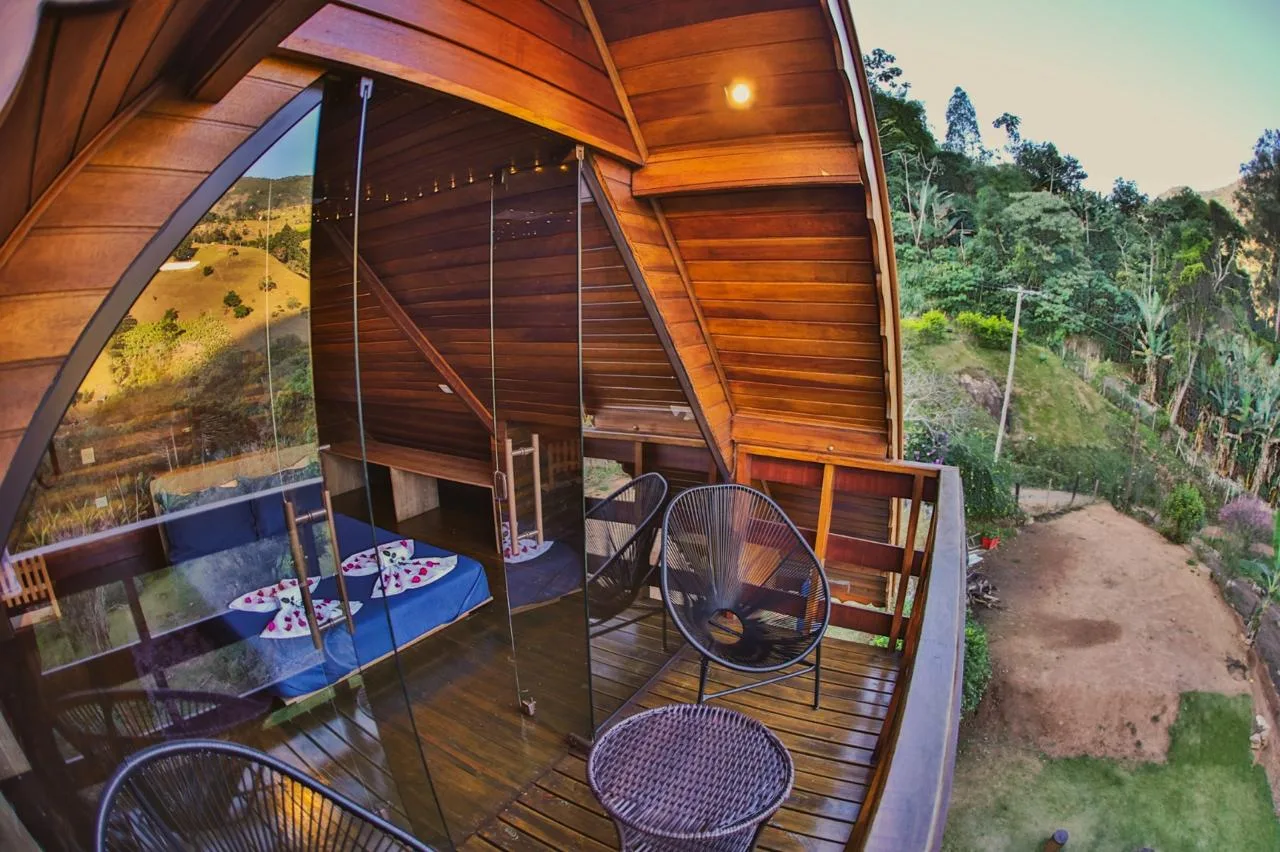 Varanda do chalé com poltronas e vista para a natureza ao redor